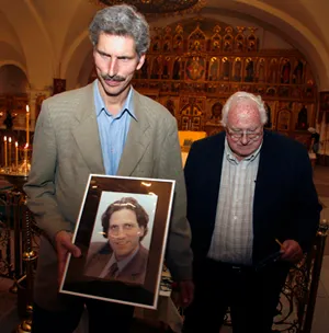 Peter Klebnikov holds a portrait of his slain brother at a service in Moscow. The Klebnikovs’ uncle, Arkady Nebolsin, stands beside him. (AP/Mikhail Metzel )