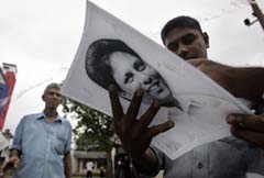 Lasantha's colleagues hold his portrait after his death. (Amarasinghe/AP)