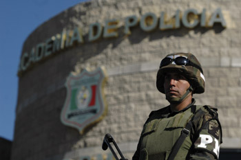Un soldado cuida una estación de policía en Ciudad Juárez. Las fuerzas federales están apoyando a la policía local. (AP)