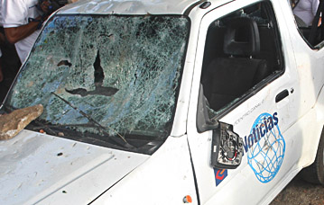 Vándalos atacaron un vehículo de la prensa durante disturbios electorales. (AP)