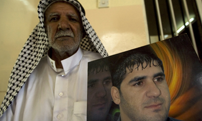Ibrahim Jassam's photo is shown by his father in Baghdad. (Reuters/Thaier al-Sudani)
