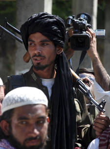 A cameraman films a Taliban militant in Daggar. (AP)