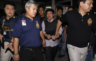 Andal Ampatuan Jr. is escorted to his trial. (Reuters)