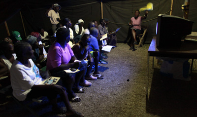 Haitian refugees watch TV in a Port-au-Prince camp. (AP)