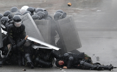 Kyrgyz police, after firing on protesters, come under attack from an angry crowd. (AP/Ivan Sekretarev)