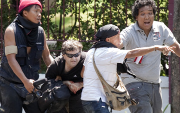 Rand is helped by protesters after being shot near Lumpini Park. (Reuters/Adrees Latif)