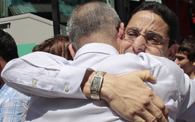Los periodistas liberados Normando Hernández González (derecha) y Omar Rodríguez Saludes se abrazan en su arribo a Madrid (AP/Arturo Rodríguez)