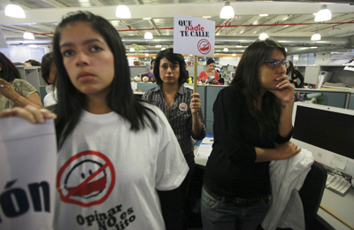 An El Nacional journalist holds a sign that reads "Don´t let anybody silence you" during a protest at the paper's newsroom in Caracas on August 18. (AP/Fernando Llano)