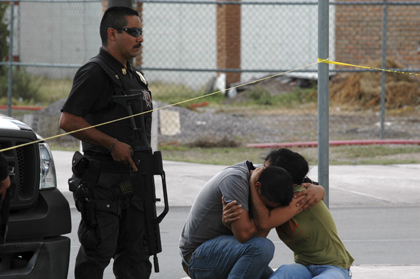 Relatives of slain photojournalist Luis Carlos Santiago at the scene of the crime.(AP/Raymundo Ruiz)
