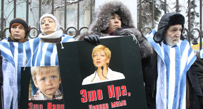 Demonstrators hold signs for jailed journalist Irina Khalip and her son. (Reuters/Sergei Karpukhin)