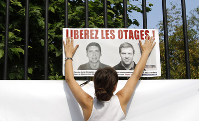 A poster in the Jardin du Luxembourg in Paris shows French hostages Stephane Taponier (left) and Herve Ghesquiere. (Reuters/Benoit Tessier)