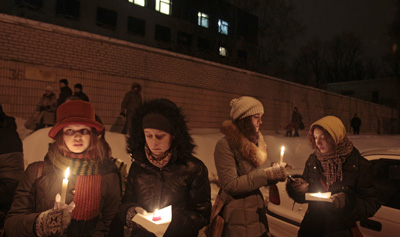 Supporters light candles today outside prison walls in Minsk for those detained in Belarus' Sunday opposition protests. (AP/Dmitry Brushko)