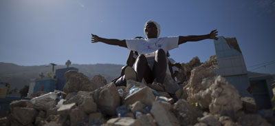 A woman prays in the rubble of the national cemetery in Port-au-Prince today, one year after a devastating eartthquake. (AP/Ramon Espinosa)