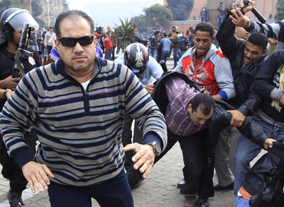Plainclothes police chase what Reuters says is unidentified foreign journalist today in Cairo. (Reuters /Goran Tomasevic )