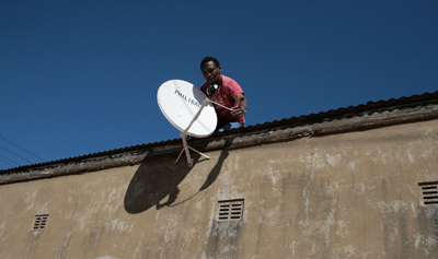 A man sets up a satellite dish in Zimbabwe, where state news is severely restricted on the ongoing protests in the Middle East, but where CNN is still accessible. (AP)