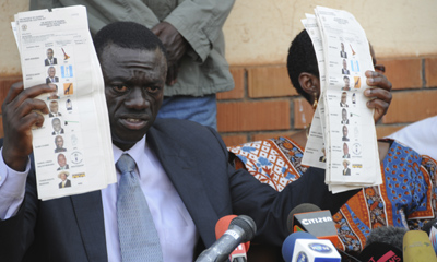 Opposition leader Kizza Besigye displays pre-marked ballot papers during a news conference Kampala. Election-rigging has been alleged in national and local polls. (AP/Stephen Wandera)