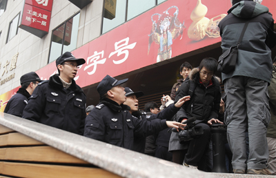 Police ask journalists to leave as they cover people gathering at a planned protest site in Beijing on Feb. 20, 2011. (AP/Andy Wong)