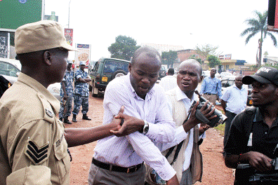 A police officer manhandles a journalist during a Walk to Work protest. (Joseph Kiggundu/The Monitor)