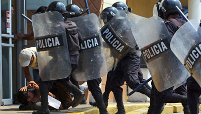 Policía antidisturbios detiene a un manifestante durante una huelga general en Tegucigalpa (AP/Fernando Antonio)