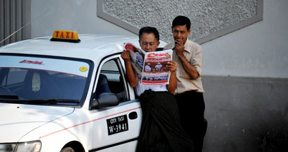 Burmese taxi drivers read a newspaper featuring a picture of newly sworn-in president Thein Sein. (AFP/Soe Than Win)