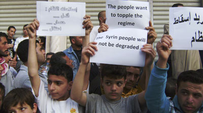 Syrians carry banners during an anti-government protest in the coastal town of Banias, Syria. (AP)