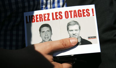 'Free the hostages!' was the rallying cry for those seeking the release of Hervé Ghesquière, left, and Stéphane Taponier. (AFP/Michel Gangne)