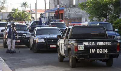 Police outside the home of slain columnist Miguel Ángel López Velasco. His wife and son were also murdered. (AP/Felix Marquez)
