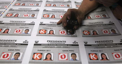 Un trabajador examina las boletas electorales con imágenes de los candidatos presidenciales en Perú. (AP/Martin Mejia)