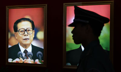 At a Beijing exhibition, a portrait of Jiang and a security guard. (Reuters)