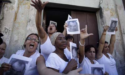 In Cuba, the Ladies in White were instrumental in drawing attention to the plight of imprisoned journalists and dissidents. Here, they hold a photo of Orlando Zapata Tamayo, who died in custody. (AP/Javier Galeano)