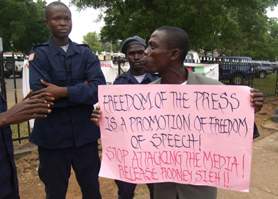 A man in Liberia holds a sign in support of Rodney Sieh, whose newspaper was found guilty of libel. (Aaron Leaf)