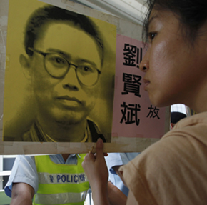 In Hong Kong, a protester holds a portrait of the jailed writer Liu Xianbin. (Reuters)