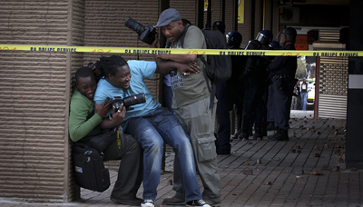 Journalists take cover while Malema supporters protest the ANC leader's disciplinary hearing. (Daniel Born/The Times)