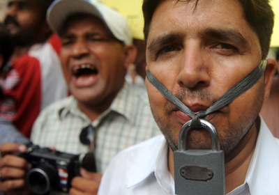 A journalist hangs a lock across his lips during a protest in response to the death of journalist Saleem Shahzad. (AFP)
