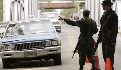 Colombian police officers stop a car at the Arauca City border. (Reuters)