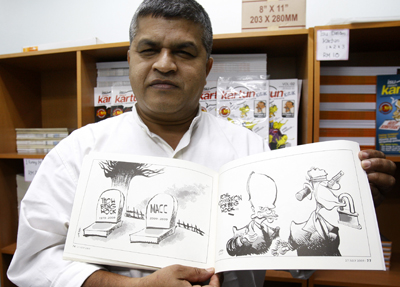 Zunar displays a copy of his previously banned cartoons. (AP)