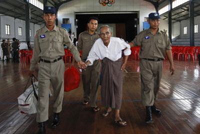 Police assist a newly released prisoner at Insein Prison in Yangon Wednesday. (Reuters)