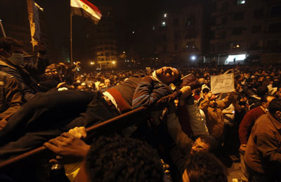 Protesters carry a man wounded during clashes with Egyptian riot police in Tahrir Square Monday, Nov. 21, 2011. (AP)