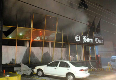 Smoke pours out from the front of the El Buen Tono offices. (Reuters)