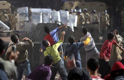 Protesters throw stones at Egyptian soldiers during clashes in Cairo on Sunday. (AP/Nasser Nasser)