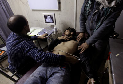 Doctors treat Associated Press cameraman Umar Meraj after he was assaulted by police and paramilitary forces using rifle butts, batons, fists and kicks during a protest in Srinagar on November 25 (AP).