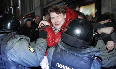 Police officers attempt to detain a journalist from Kommersant during a rally in Russia protesting the results of the parliamentary elections. (Reuters)