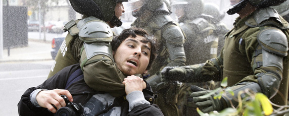 Полиция в Сантьяго задерживает фотографа на антиправительственной акции протеста. (Рейтер/Карлос Вера)