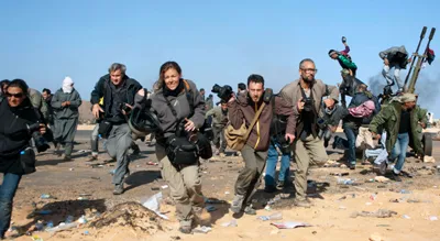 Journalists run for cover during a bombing raid in Ras Lanuf, Libya. (Reuters/Paul Conroy)