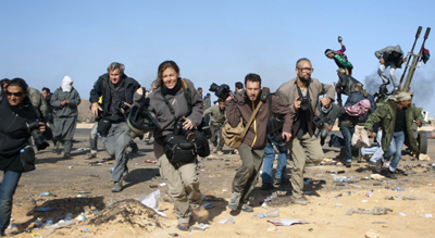 Journalists run for cover during a bombing raid in Ras Lanuf, Libya. (Reuters/Paul Conroy)