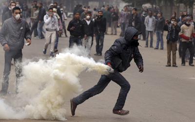 An Egyptian protester throws back a gas canister during clashes with security forces in Cairo this weekend, in which at least two journalists were attacked. (Reuters/Mohammed Salem)