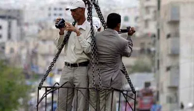 From a crane high above a protest, journalists film crowds in the Yemeni city of Taiz. (Reuters/Khaled Abdullah)