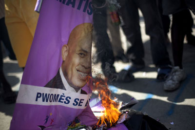 Demonstrators burn signs with images of Haitian President Michel Martelly during a protest in Port-au-Prince on February 7, 2012. (AP/Ramon Espinosa)