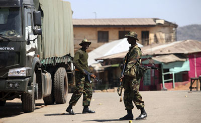 Nigerian soldiers stand guard in the central city of Jos. (Reuters/Akintunde Akinleye)