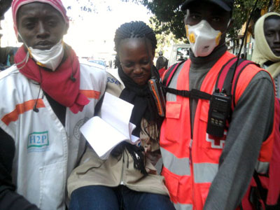 Reporter Sophie Barro is carried by medical personnel after being injured while covering protests on February 17. (Basile Niang)